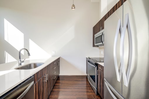 a kitchen with stainless steel appliances and a sink at The Hayes on Stone Way, Seattle, WA