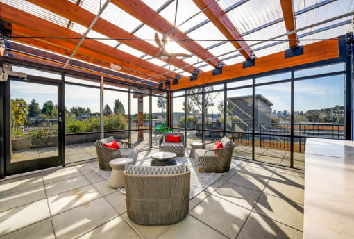 The Hayes on Stone Way Apartments patio with wicker chairs and a glass roof at The Hayes on Stone Way, Seattle, WA, 98103