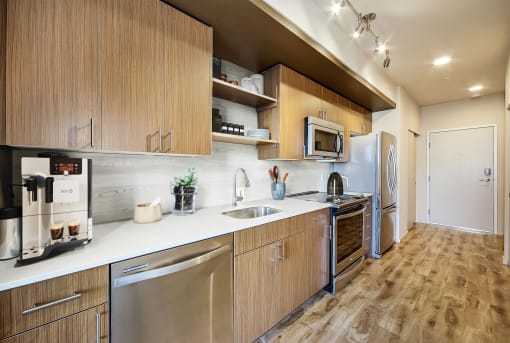 a kitchen with wooden cabinets and stainless steel appliances at The Hayes on Stone Way, Washington