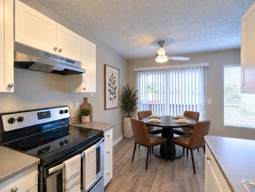 A modern kitchen with a black stove top oven and white cabinets.