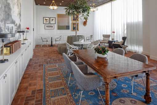 A dining room with a wooden table surrounded by chairs.