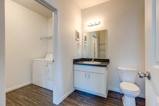 A small white bathroom with a toilet, sink, and medicine cabinet.