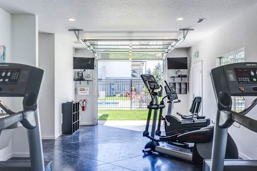A gym with treadmills and elliptical machines.