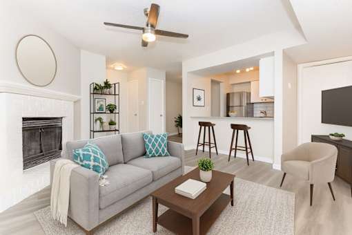 A living room with a grey couch, a coffee table, and a fireplace.