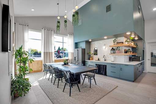 A modern kitchen with a dining table and chairs in the foreground.