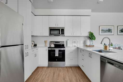 A modern kitchen with white cabinets and stainless steel appliances.