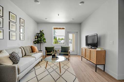A living room with a couch, a coffee table, and a television.