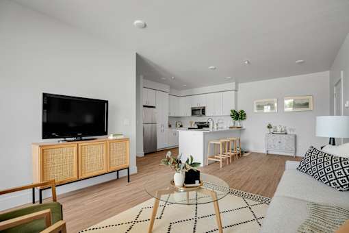A modern living room with a television, a sofa, and a coffee table.