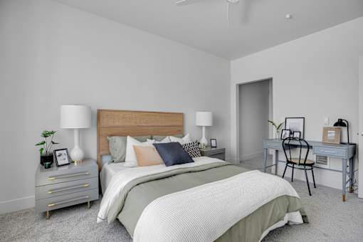 A bedroom with a bed, desk, and chair.