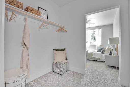A room with a chair and a basket on the wall.