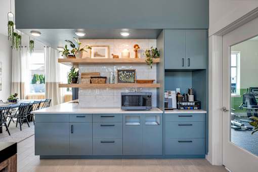 A kitchen with a grey cabinet and a white countertop.