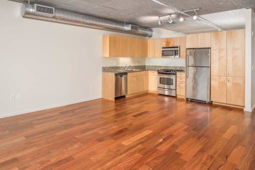 A kitchen with wooden cabinets and a stainless steel refrigerator.