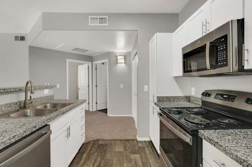 A kitchen with a black stove top oven and a black microwave above the stove.