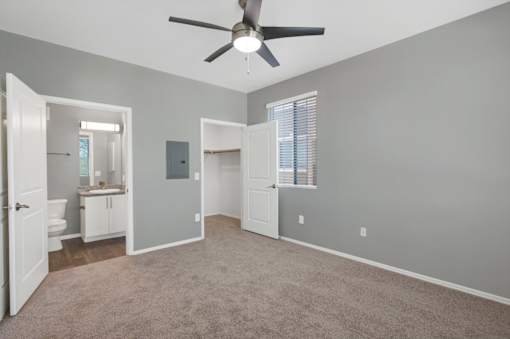 A room with a ceiling fan and carpeted floor.