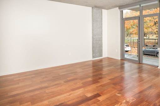 A room with wooden flooring and a sliding glass door.