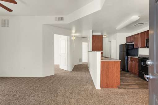 A living room with a brown carpet and a white ceiling.
