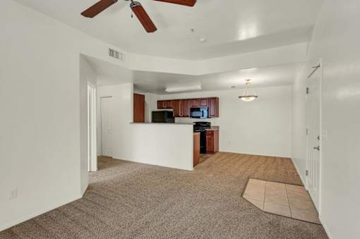 A spacious living room with a ceiling fan and a television.