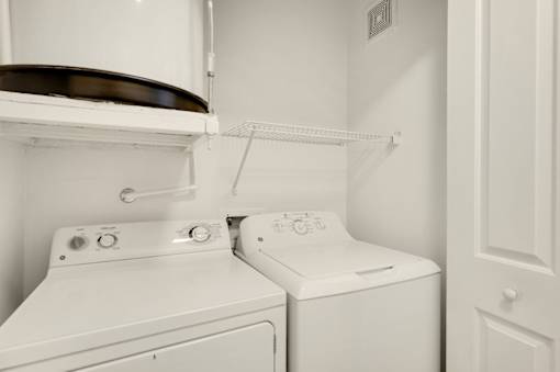 A white washing machine and dryer in a small laundry room.