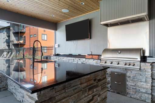 a kitchen with a stove top oven and a flat screen tv