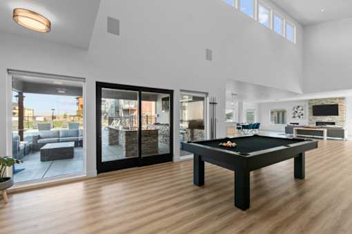 a living room with a pool table in the middle of it