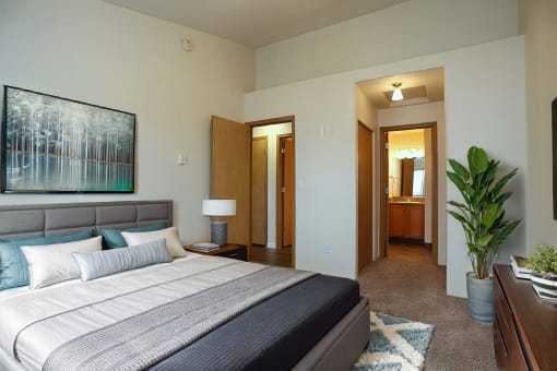 a bedroom with a bed and a potted plant