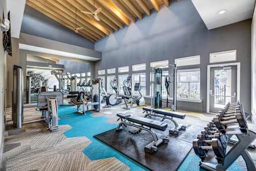 A spacious gym with a variety of equipment including treadmills, weights, and exercise machines.