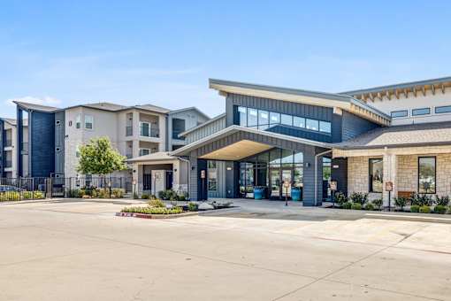 A modern building with a parking lot in front.