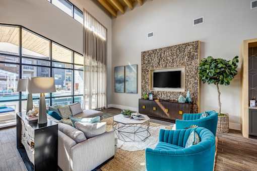 A living room with a blue armchair and a grey couch.