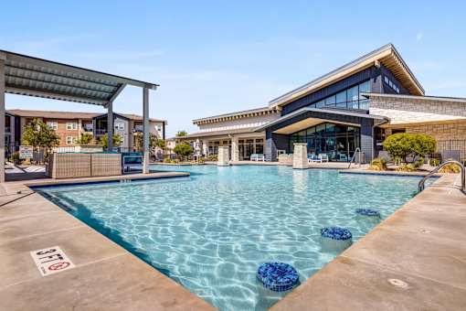 A swimming pool with a building in the background.