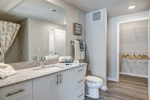 A bathroom with a white toilet, sink, and a mirror.