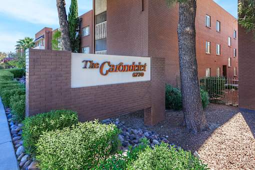 The Carondalot sign is on a brick wall.