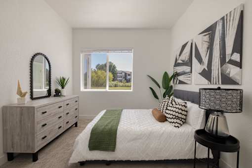 a bedroom with a bed and a dresser and a window