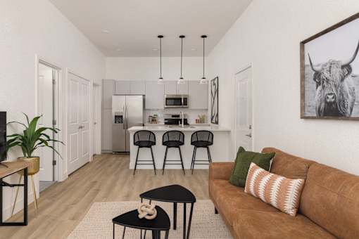 a living room with a couch and a kitchen with a
