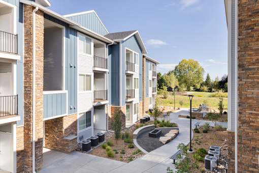 an exterior view of an apartment building with a pathway and landscaping