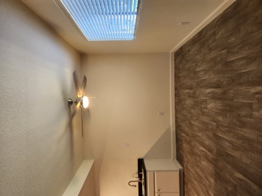 a bathroom with a skylight and a light on the wall