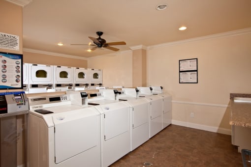 the laundry room is equipped with washer and dryers and a ceiling fan