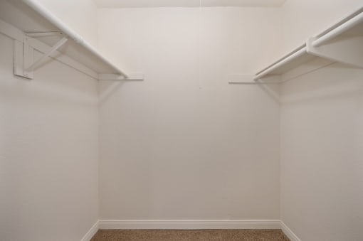 an empty room with white walls and two white shelves