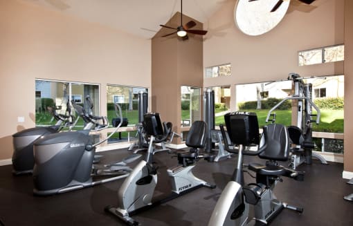 a gym with exercise machines and a ceiling fan