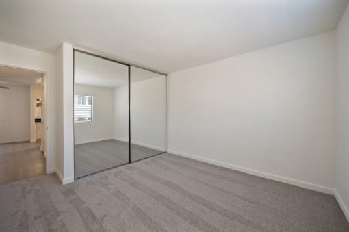 a living room with a carpeted floor and a sliding glass door