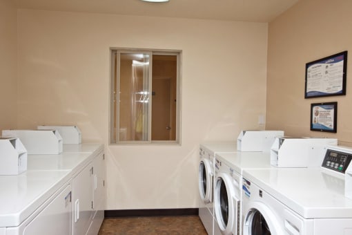 a washer and dryer room with washing machines and dryers