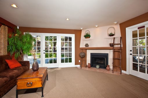 a living room with brown carpet and a fireplace
