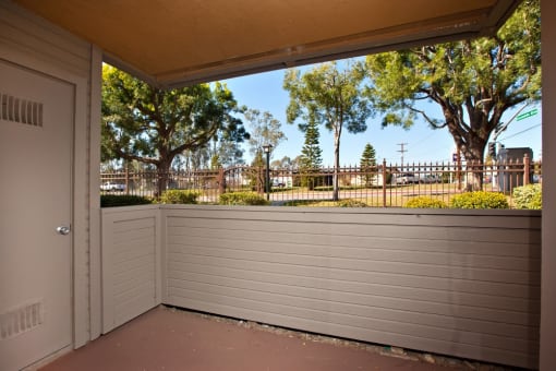 a patio with a door and a fence in the background