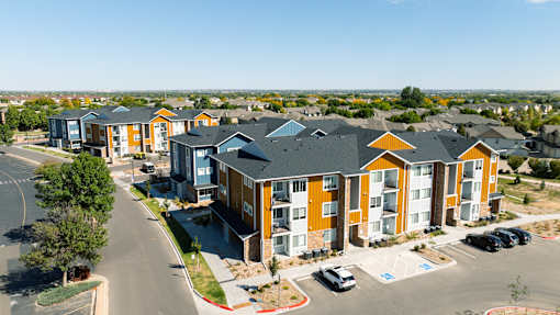 an aerial view of an apartment complex with cars parked in front of it