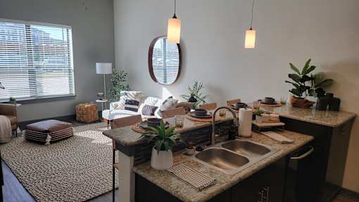 A kitchen with a sink, a mirror, and a rug at Urban Square, Denton, TX, 76210