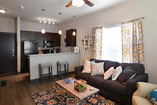 Living room with a large window and a wooden floor at H Squared Apartments, Denton