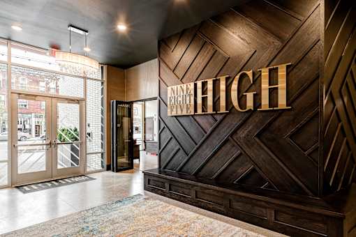 The lobby of a building with a large sign at 985 High Apartments, Columbus, 43201
