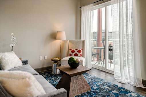 A living room with a grey couch and a wooden coffee table. at 985 High Apartments, Columbus, 43201