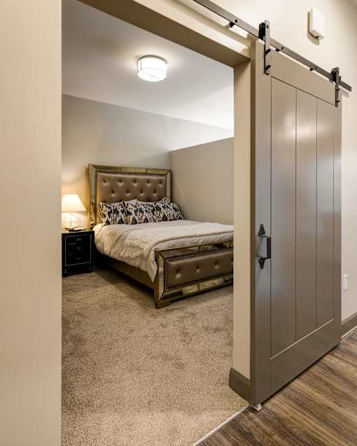 A bedroom with a bed, nightstand, and a sliding door. at 985 High Apartments, Columbus, OH, 43201