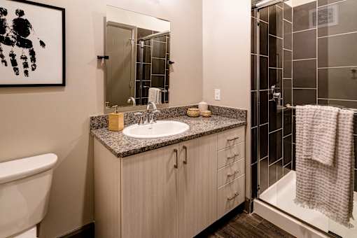 A bathroom with a sink, mirror, and towel rack. at 985 High Apartments, Ohio, 43201
