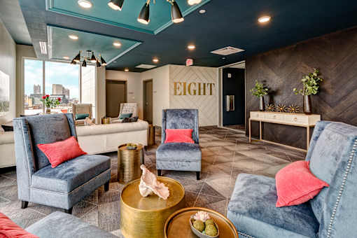 A living room with a blue chair and a gold coffee table. at 985 High Apartments, Columbus, OH, 43201